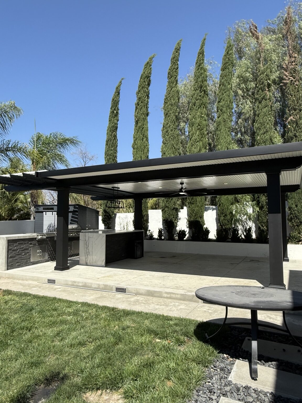 Finished black and white Total Patio cover over an outdoor kitchen